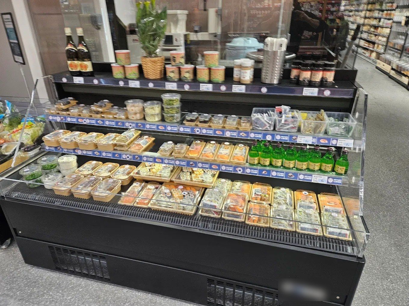 Vitrine réfrigérée libre-service à sushis avec barquettes, étagères et étiquetage de prix