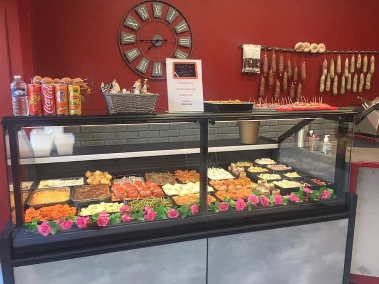 Vitrine réfrigérée traiteur à vitrage droit garnie de plats cuisinés et de salades
