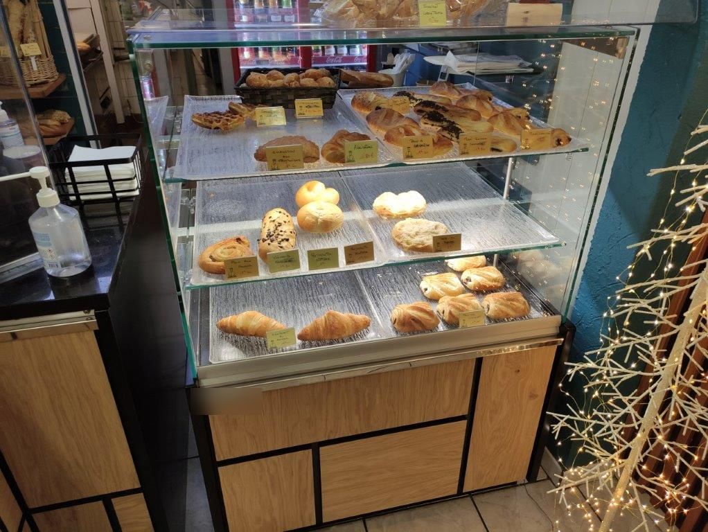 Vitrine à trois niveaux garnie de viennoiseries et de brioches dans une boulangerie